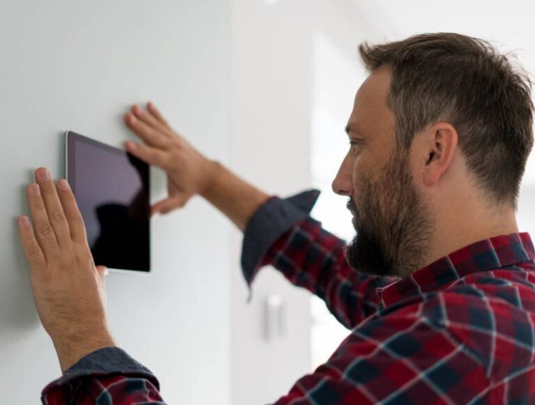 man adjusting thermostat